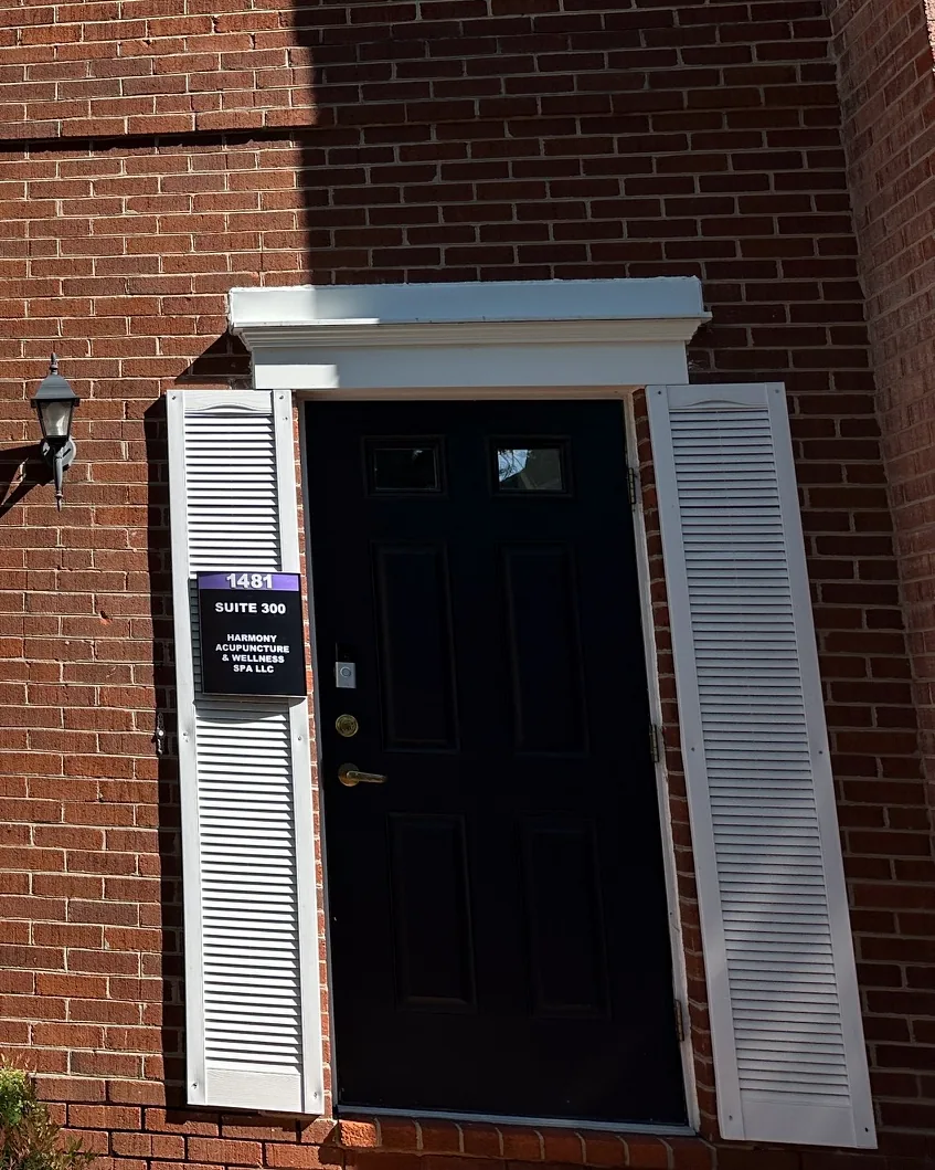 Street entrance at 1481 Chain Bridge Rd — red brick building with white shutters and the black door leading to Ste 300