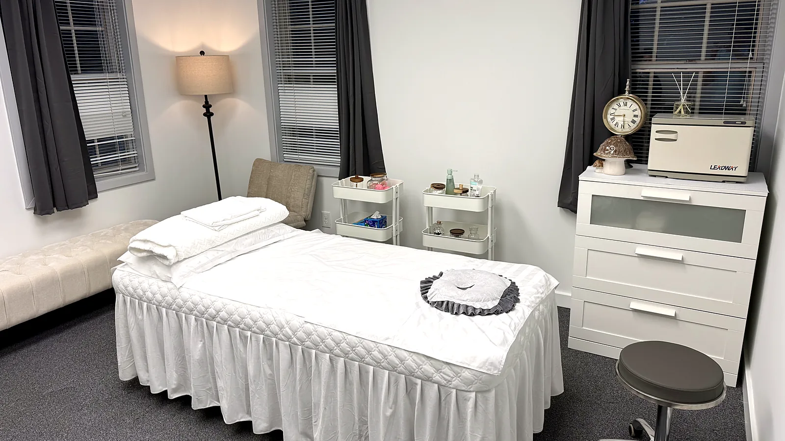 Treatment room at Harmony Acupuncture & Wellness Spa in McLean with a white skirted table, folded towels, and a towel warmer