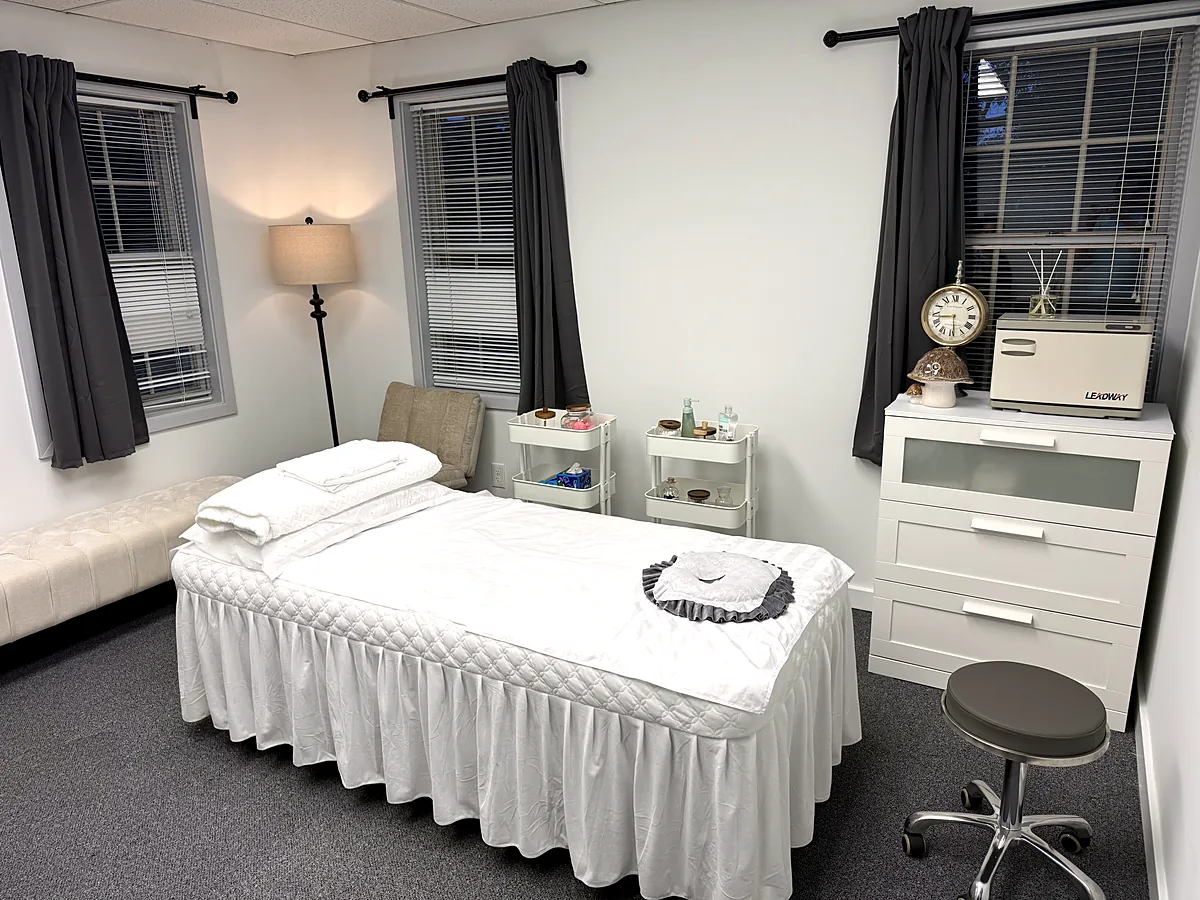 Treatment room at Harmony Acupuncture & Wellness Spa prepared with towels and a floor lamp