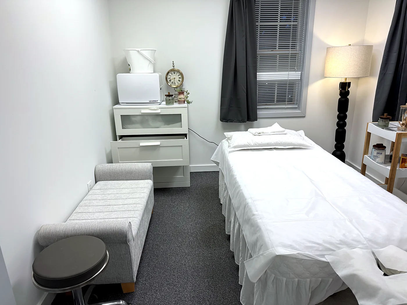 Treatment room at Harmony Acupuncture & Wellness Spa in McLean with a made-up table, folded towel, and warm lamp light